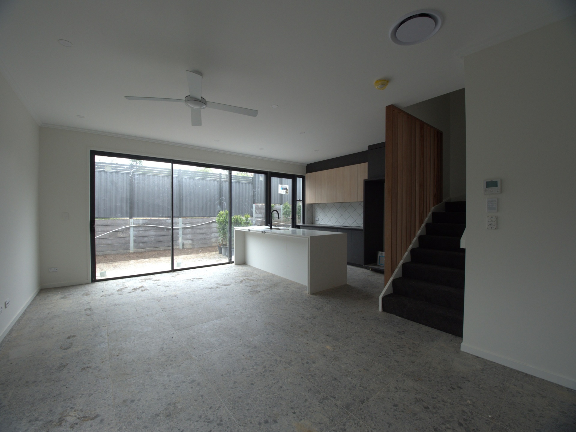Before photo of bare living area with kitchen island